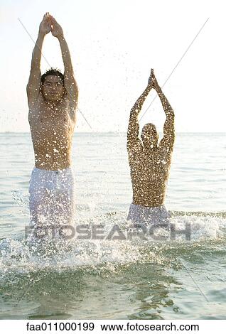 Two men emerging from water View Large Photo Image Stock Photo - Two men emerging from water. Fotosearch