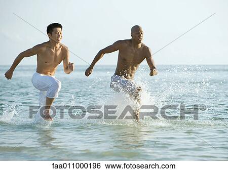 Stock Photograph - Two men running in sea. Fotosearch