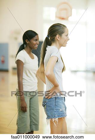 Stock Photo - Two teen girls standing in school gym. Fotosearch