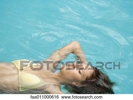 Woman floating on back in pool View Large Photo Image Stock Photograph - Woman floating on back in pool. Fotosearch
