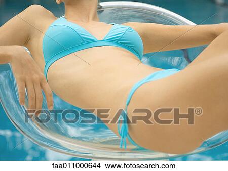Woman in bikini lounging in transparent chair View Large Photo Image Picture - Woman in bikini lounging in transparent chair. Fotosearch