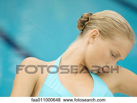 Stock Photo - Woman in bikini sitting by pool, head on shoulder. Fotosearch