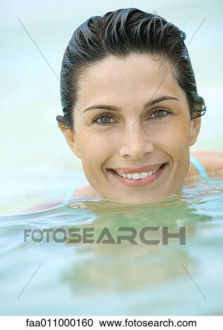 Stock Image - Woman in water, smiling, close-up. Fotosearch