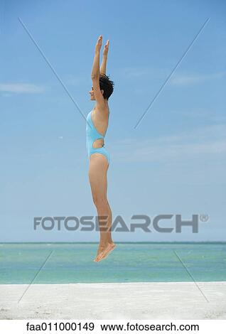 Woman jumping on beach, side view View Large Photo Image Stock Photo - Woman jumping on beach, side view. Fotosearch
