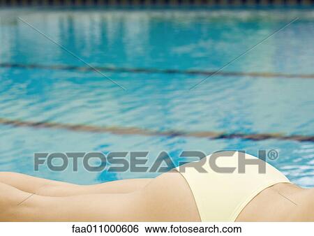 Woman lounging by pool on stomach, cropped view of buttocks and legs View Large Photo Image Stock Photograph - Woman lounging by pool on stomach, cropped view of buttocks and legs. Fotosearch