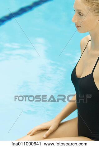 Stock Image - Woman sitting by pool. Fotosearch