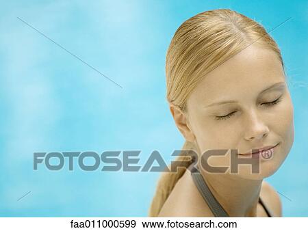 Woman smiling with eyes closed, water in background View Large Photo Image Stock Photo - Woman smiling with eyes closed, water in background. Fotosearch