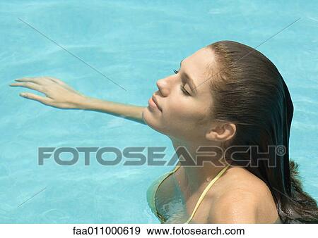 Woman standing in pool, head back and eyes closed, side view View Large Photo Image Stock Photo - Woman standing in pool, head back and eyes closed, side view. Fotosearch