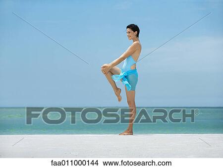 Picture - Woman stretching on beach. Fotosearch
