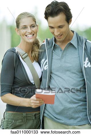 Young couple, woman showing man book View Large Photo Image Stock Image - Young couple, woman showing man book. Fotosearch