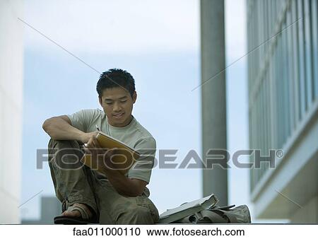 Stock Image - Young man studying outdoors on campus. Fotosearch