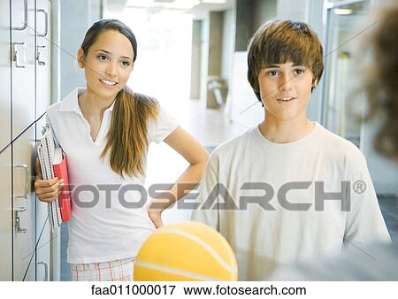 Young teens standing near school lockers View Large Photo Image Stock Photo - Young teens standing near school lockers. Fotosearch