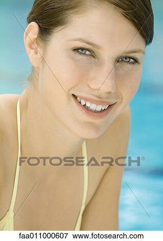 Young woman by pool, smiling, portrait View Large Photo Image Stock Photo - Young woman by pool, smiling, portrait. Fotosearch