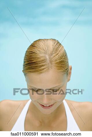 Stock Image - Young woman looking down. Fotosearch