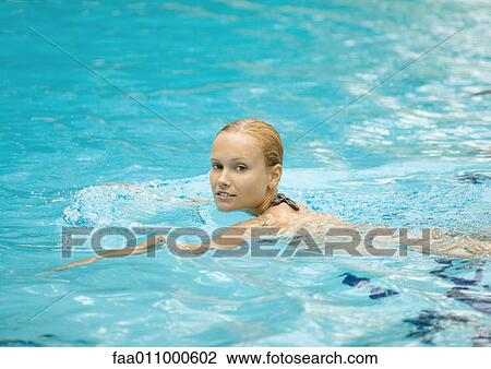 Young woman swimming in pool View Large Photo Image Stock Image - Young woman swimming in pool. Fotosearch