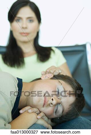 Boy sleeping on mother's lap in airport lounge View Large Photo Image Stock Photo - Boy sleeping on mother's lap in airport lounge. Fotosearch