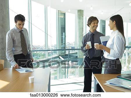 Business colleagues standing with cups of coffee, chatting View Large Photo Image Stock Photograph - Business colleagues standing with cups of coffee, chatting. Fotosearch