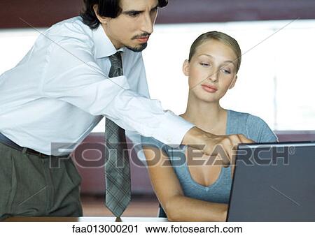 Businessman helping businesswoman with laptop View Large Photo Image Stock Image - Businessman helping businesswoman with laptop. Fotosearch