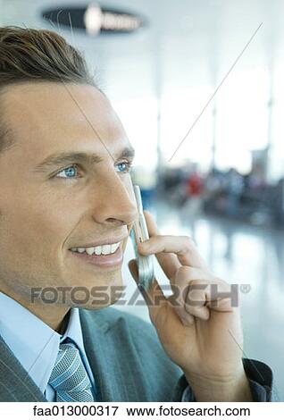 Businessman using cell phone in airport View Large Photo Image Stock Photo - Businessman using cell phone in airport. Fotosearch