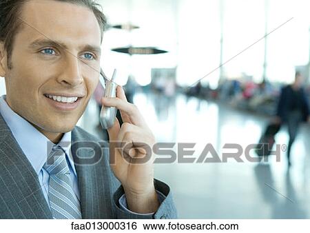 Businessman using cell phone in airport View Large Photo Image Stock Photograph - Businessman using cell phone in airport. Fotosearch