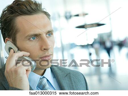 Businessman using cell phone in airport View Large Photo Image Stock Photography - Businessman using cell phone in airport. Fotosearch