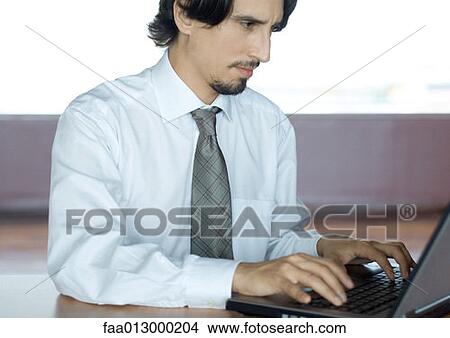 Businessman using laptop at desk View Large Photo Image Picture - Businessman using laptop at desk. Fotosearch