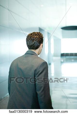 Stock Photo - Businessman walking through corridor. Fotosearch