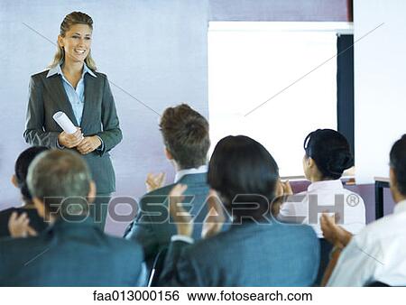 Stock Photograph - Businesspeople in seminar, audience clapping. Fotosearch