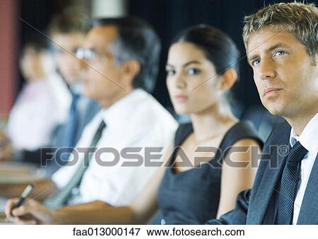 Businesspeople sitting, looking attentively out of frame View Large Photo Image Stock Photo - Businesspeople sitting, looking attentively out of frame. Fotosearch