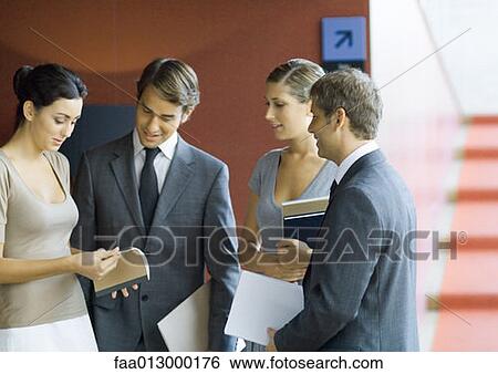 Businesspeople standing, making plans View Large Photo Image Stock Photograph - Businesspeople standing, making plans. Fotosearch