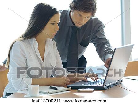 Stock Image - Businesswoman and man working with laptop. Fotosearch