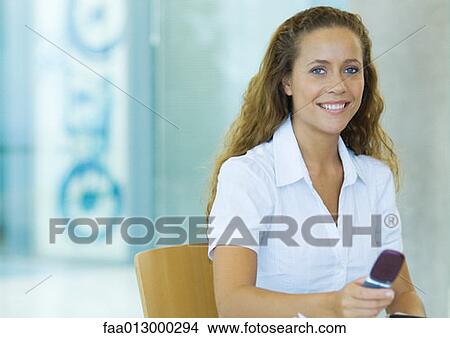 Businesswoman holding cell phone, portrait View Large Photo Image Picture - Businesswoman holding cell phone, portrait. Fotosearch