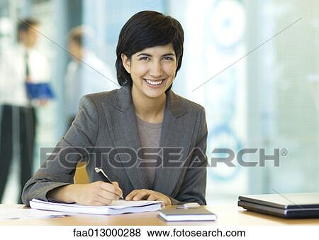 Businesswoman sitting at desk View Large Photo Image Stock Photo - Businesswoman sitting at desk. Fotosearch