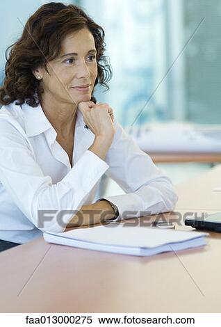 Stock Photography - Businesswoman sitting at desk. Fotosearch