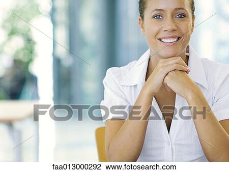 Businesswoman with hands clasped under chin, smiling, portrait View Large Photo Image Stock Image - Businesswoman with hands clasped under chin, smiling, portrait. Fotosearch