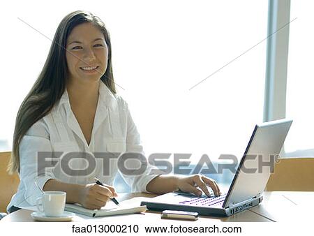 Stock Image - Businesswoman working with laptop. Fotosearch