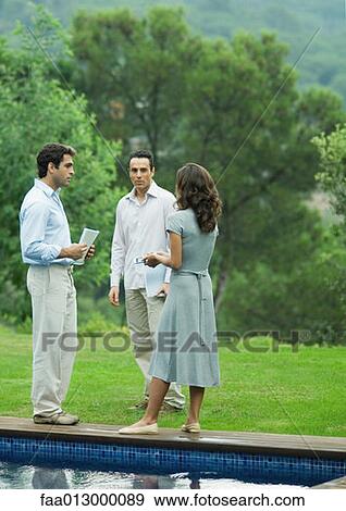 Casually dressed executives talking by side of pool View Large Photo Image Stock Photo - Casually dressed executives talking by side of pool. Fotosearch