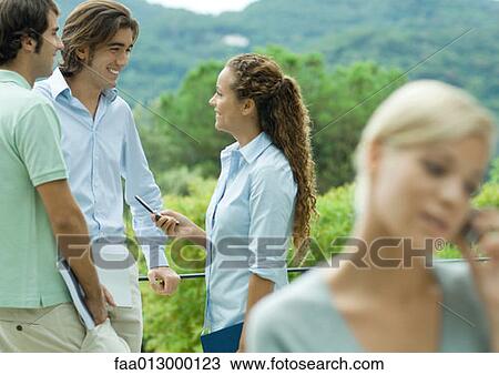 Stock Image - Casually dressed young executives talking outdoors. Fotosearch
