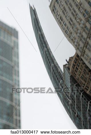 Stock Photo - Distorted reflection of highrises. Fotosearch