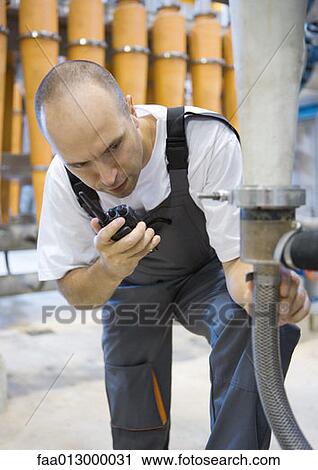 Factory worker using walkie talkie View Large Photo Image Stock Image - Factory worker using walkie talkie. Fotosearch