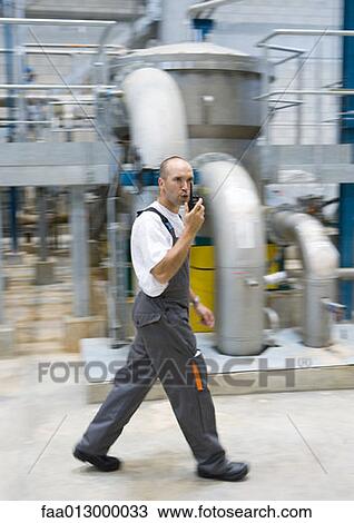 Factory worker using walkie talkie View Large Photo Image Stock Image - Factory worker using walkie talkie. Fotosearch