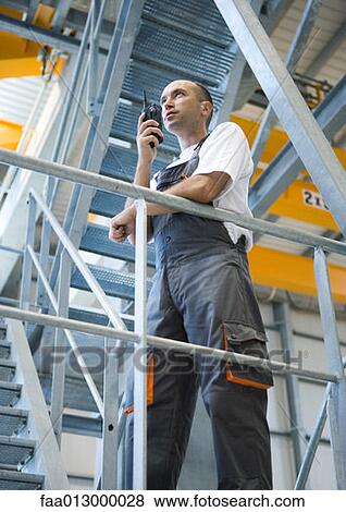 Stock Photo - Factory worker using walkie talkie. Fotosearch