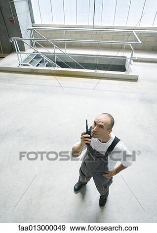 Factory worker using walkie talkie View Large Photo Image Stock Photo - Factory worker using walkie talkie. Fotosearch