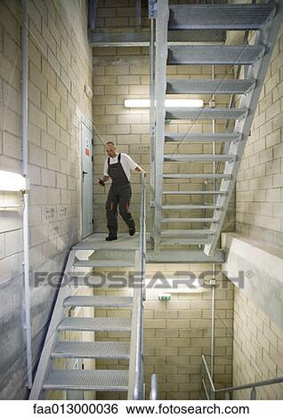Factory worker walking down stairs View Large Photo Image Stock Photograph - Factory worker walking down stairs. Fotosearch