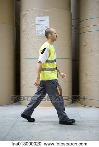 Factory worker walking past rolls of paper View Large Photo Image Stock Image - Factory worker walking past rolls of paper. Fotosearch