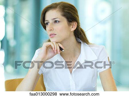 Stock Photo - Female office worker, holding pen. Fotosearch