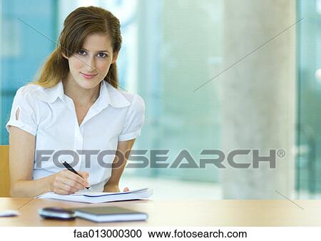 Female office worker sitting at desk, working View Large Photo Image Stock Image - Female office worker sitting at desk, working. Fotosearch
