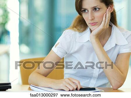Female office worker sitting at desk View Large Photo Image Stock Photo - Female office worker sitting at desk. Fotosearch