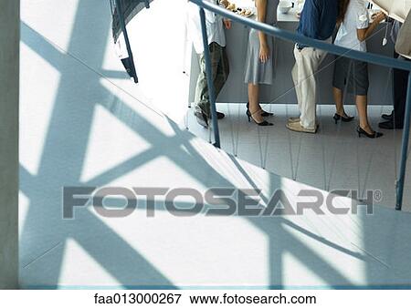 Stock Photo - Group of young executives at office party, high angle, partial view. Fotosearch