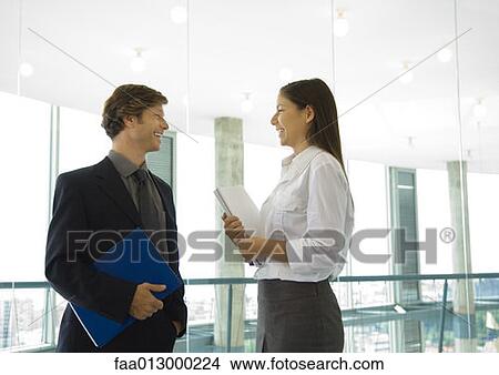 Male and female business colleagues standing, talking View Large Photo Image Picture - Male and female business colleagues standing, talking. Fotosearch